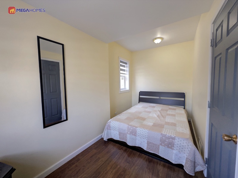 Second main floor bedroom with laminate flooring and window
