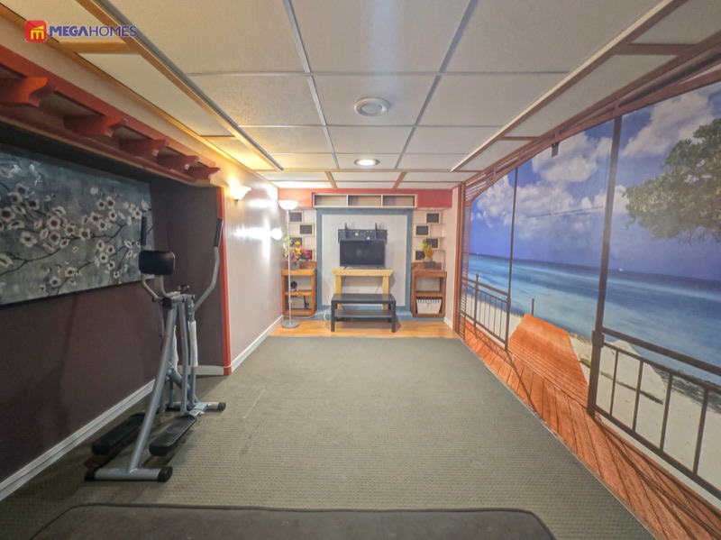 Cozy finished basement rec room with carpet and laminate flooring